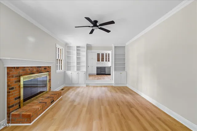 a view of empty room with wooden floor and fireplace