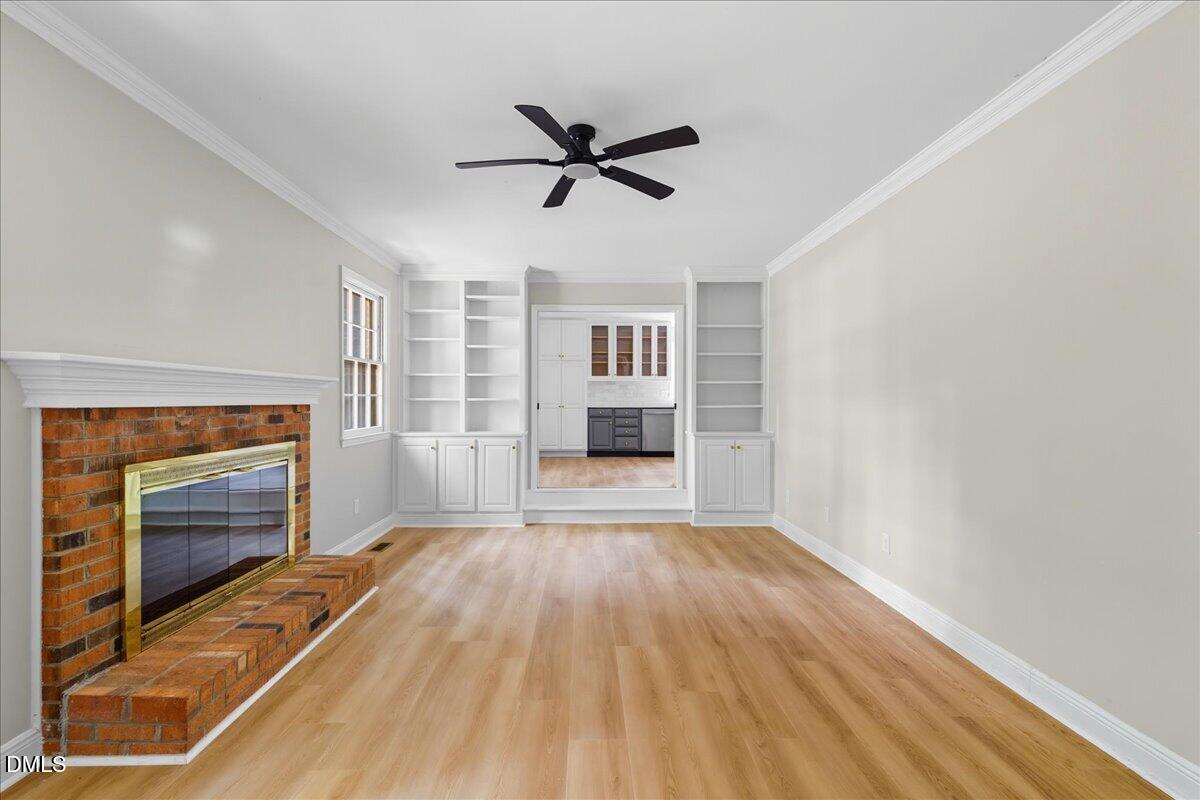 1214 East Oak Drive Durham, NC 27712 - Photo 8 of 36 a view of empty room with wooden floor and fireplace