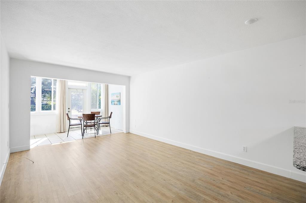 9950 47th Avenue North, Unit 104 St. Petersburg, FL 33708 - Photo 11 of 37 a view of an empty room with wooden floor and a window