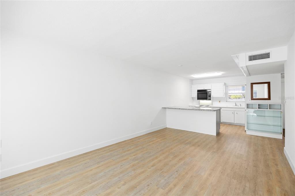 9950 47th Avenue North, Unit 104 St. Petersburg, FL 33708 - Photo 13 of 37 a view of a kitchen with wooden floor and a sink