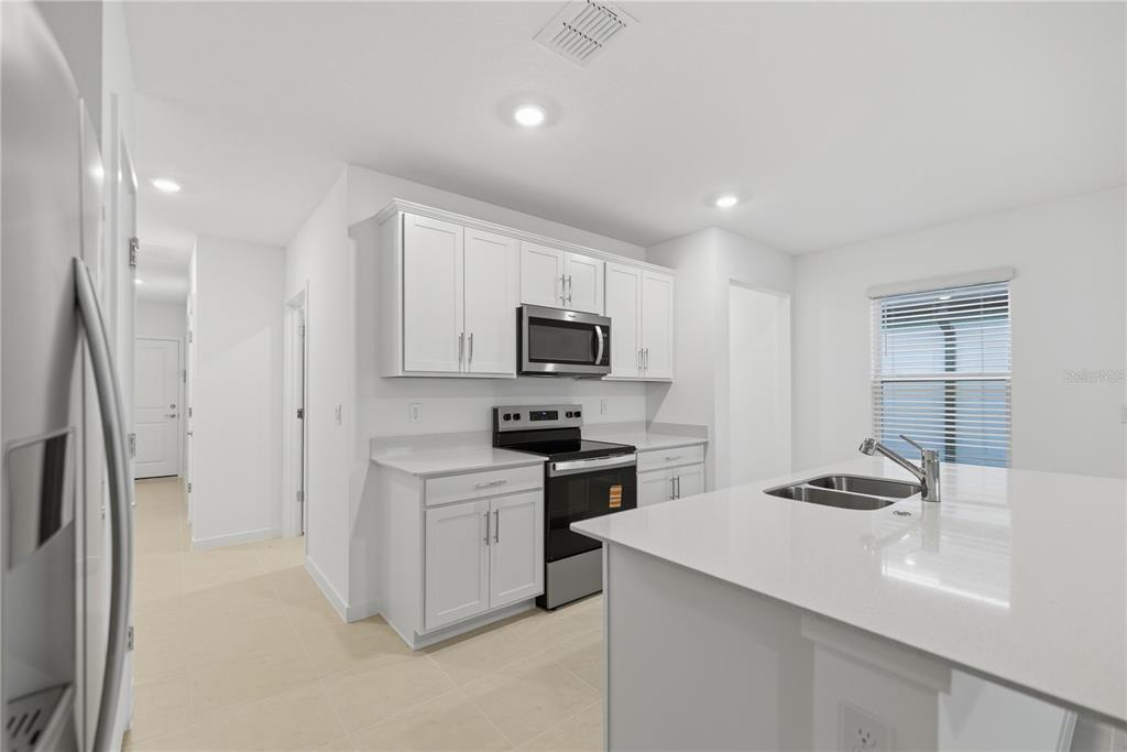 6760 Southwest 90th Loop Ocala, FL 34476 - Photo 12 of 28 a kitchen with a sink stainless steel appliances and white cabinets