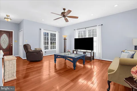 a living room with furniture flat screen tv and wooden floor