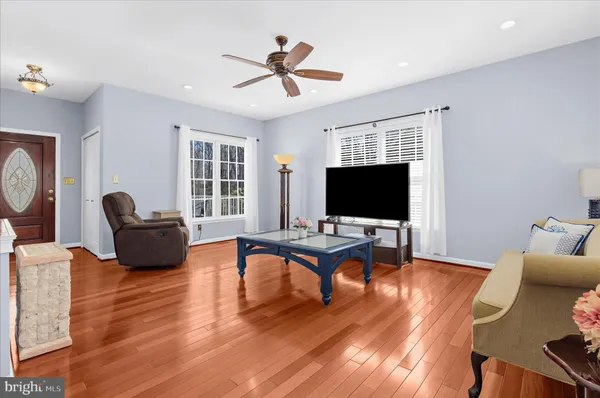 a living room with furniture flat screen tv and wooden floor