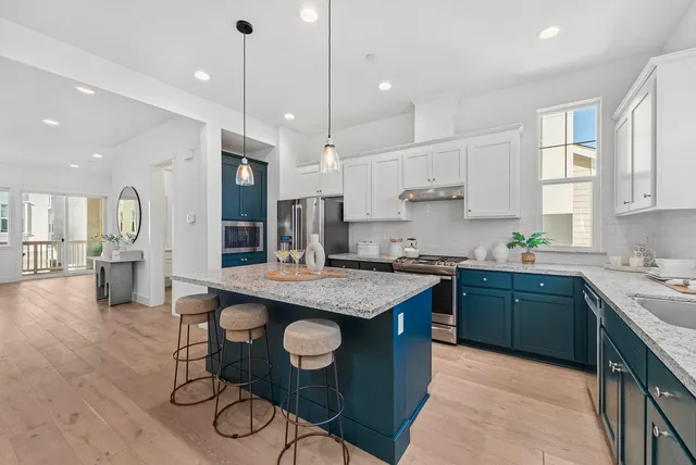 a kitchen with stainless steel appliances granite countertop counter space a sink refrigerator and cabinets