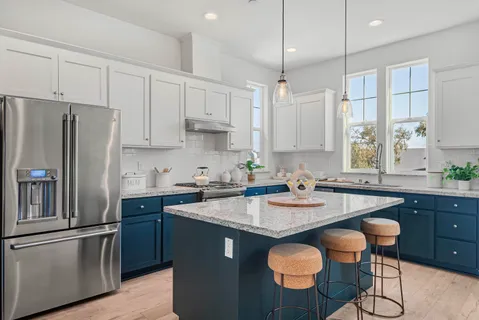 a kitchen with stainless steel appliances granite countertop a sink a stove a refrigerator and island with wooden floor