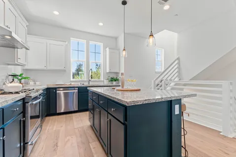 a kitchen with granite countertop a sink a counter space appliances and cabinets