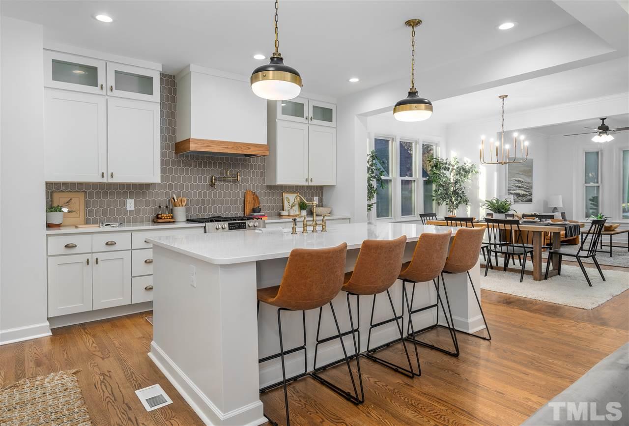 608 Hardimont Road Raleigh, NC 27609 - Photo 6 of 29 a kitchen with stainless steel appliances granite countertop a stove top oven a sink a dining table and chairs with wooden floor