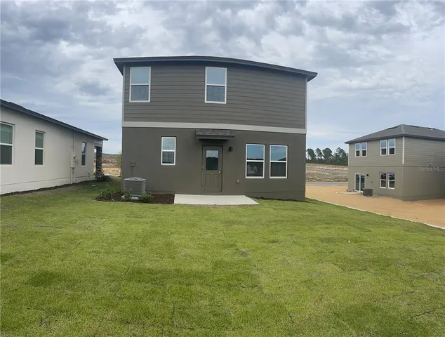 a view of a house with a big yard and large trees