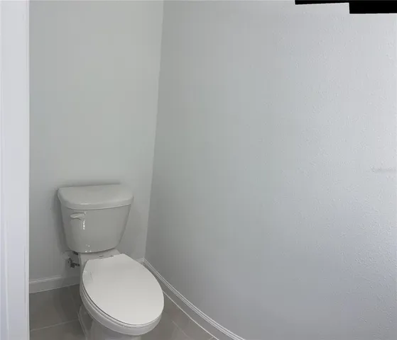 a white toilet sitting next to a white wall