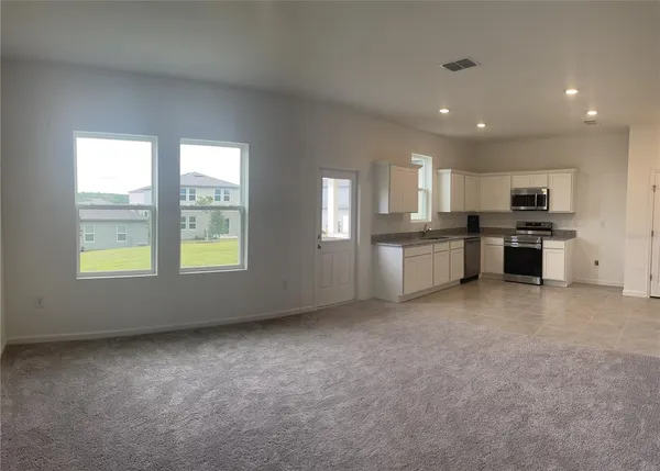 a large kitchen with kitchen island a sink stainless steel appliances and cabinets