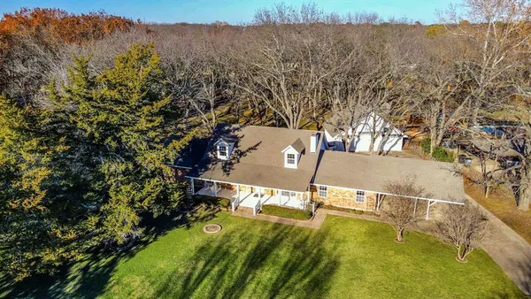 an aerial view of residential houses with outdoor space and trees