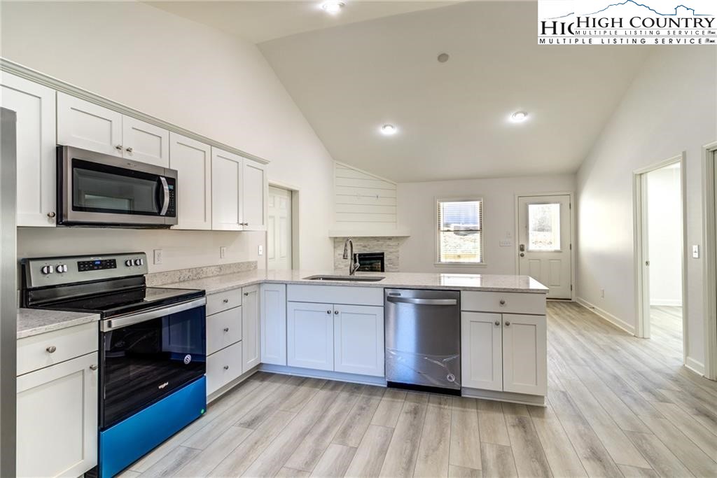 21 Townhomes Place, Unit 21 Boone, NC 28607 - Photo 12 of 19 a large kitchen with cabinets wooden floor and stainless steel appliances
