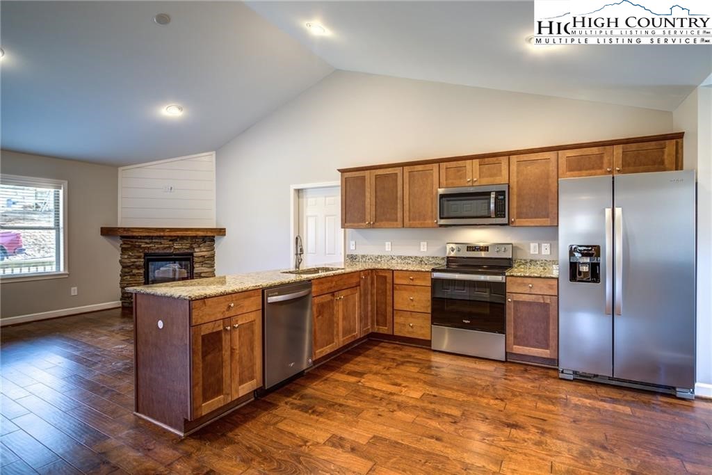 21 Townhomes Place, Unit 21 Boone, NC 28607 - Photo 4 of 19 a kitchen with stainless steel appliances granite countertop a stove top oven a sink dishwasher a refrigerator and a microwave oven with large wooden floor