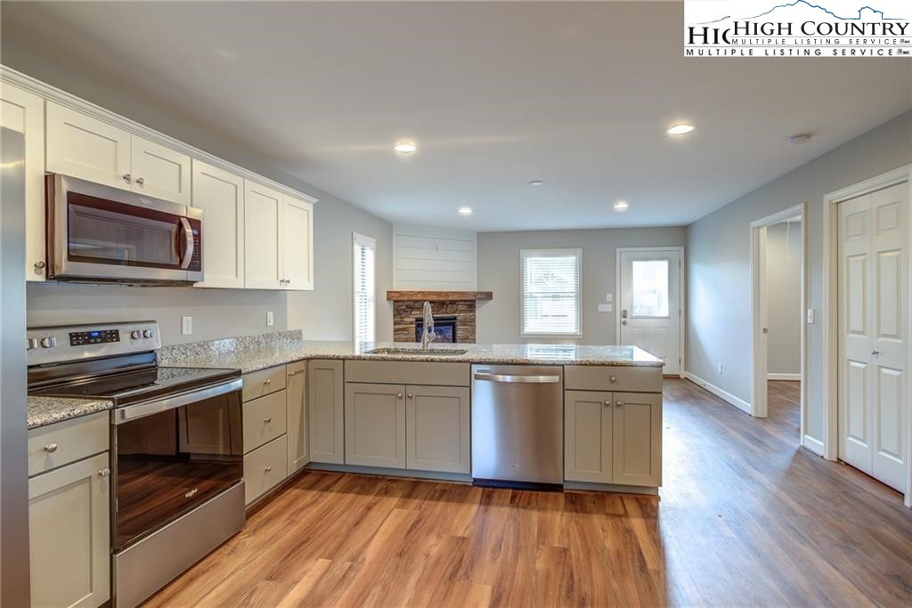 21 Townhomes Place, Unit 21 Boone, NC 28607 - Photo 7 of 19 a kitchen with stainless steel appliances granite countertop wooden cabinets and a stove top oven