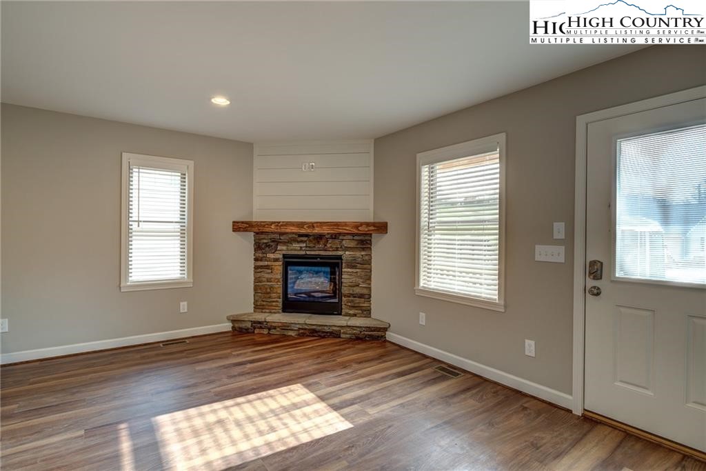 21 Townhomes Place, Unit 21 Boone, NC 28607 - Photo 8 of 19 an empty room with windows a fireplace and wooden floor