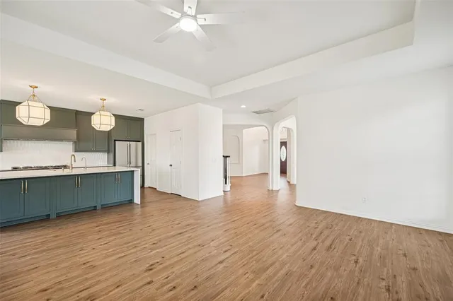 a view of an empty room with wooden floor fireplace and a window