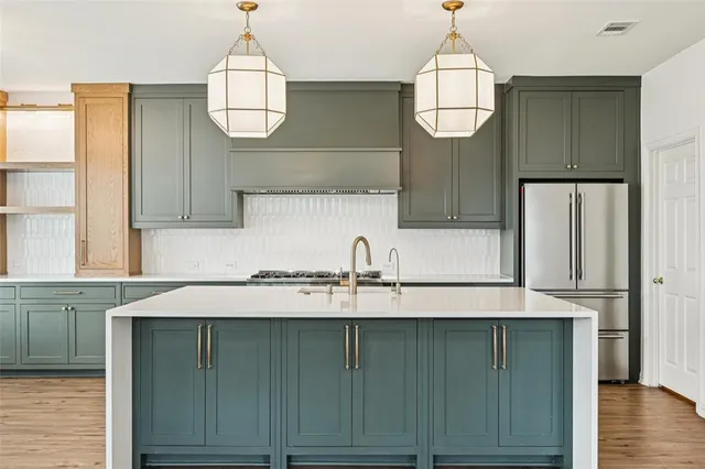 a kitchen with a sink a refrigerator and cabinets