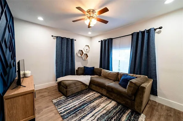 a living room with furniture ceiling fan and a rug