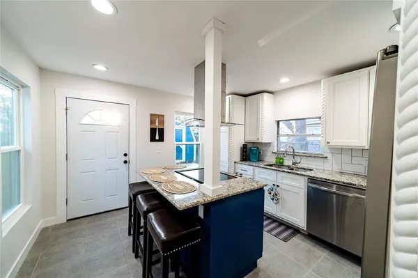 a kitchen with a sink refrigerator and cabinets