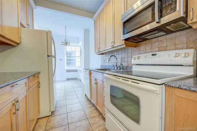 a kitchen with granite countertop cabinets stainless steel appliances and a counter space