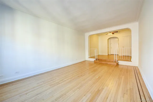 an empty room with wooden floor and mirror