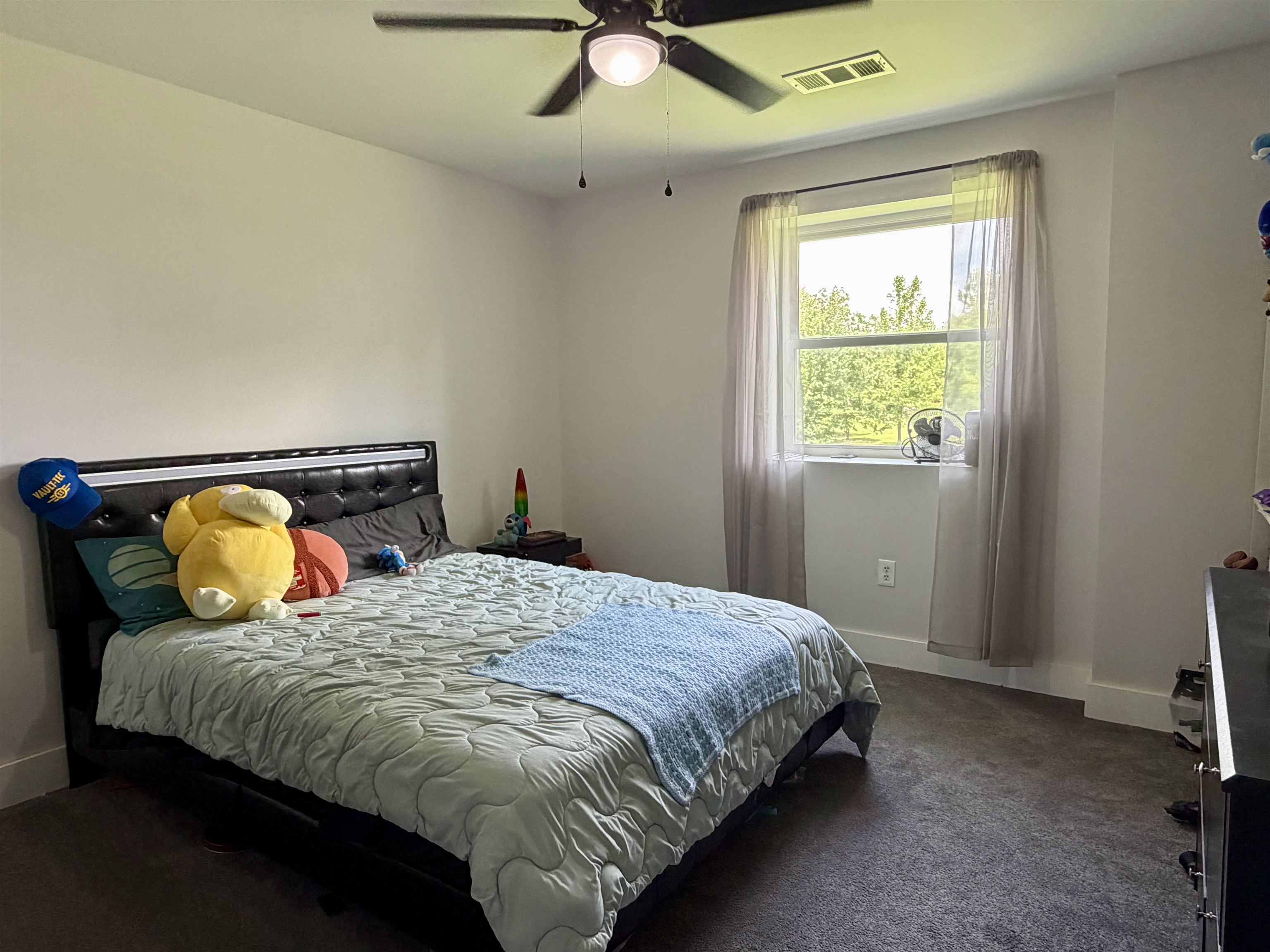 3670 Peavine Road Middleton, TN 38052 - Photo 29 of 36 Bedroom featuring a window with sheer curtains, a ceiling fan with integrated lighting, and dark carpet flooring