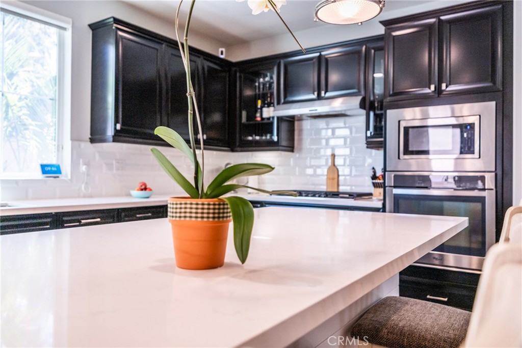 32390 Magee Lane Temecula, CA 92592 - Photo 19 of 75 a kitchen with stainless steel appliances granite countertop a refrigerator a stove and a sink with wooden cabinets