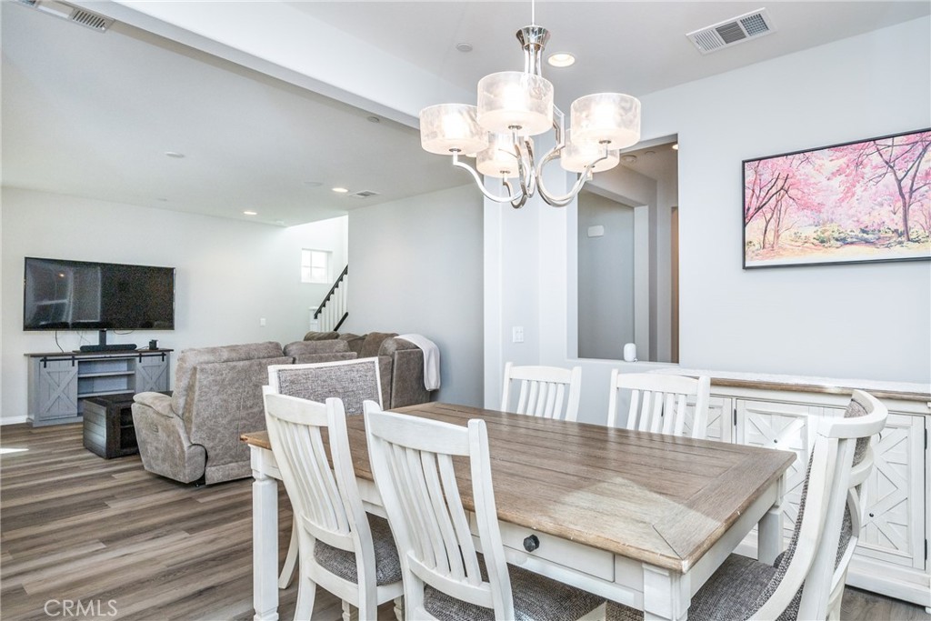32390 Magee Lane Temecula, CA 92592 - Photo 23 of 75 a view of a dining room with furniture a chandelier and wooden floor
