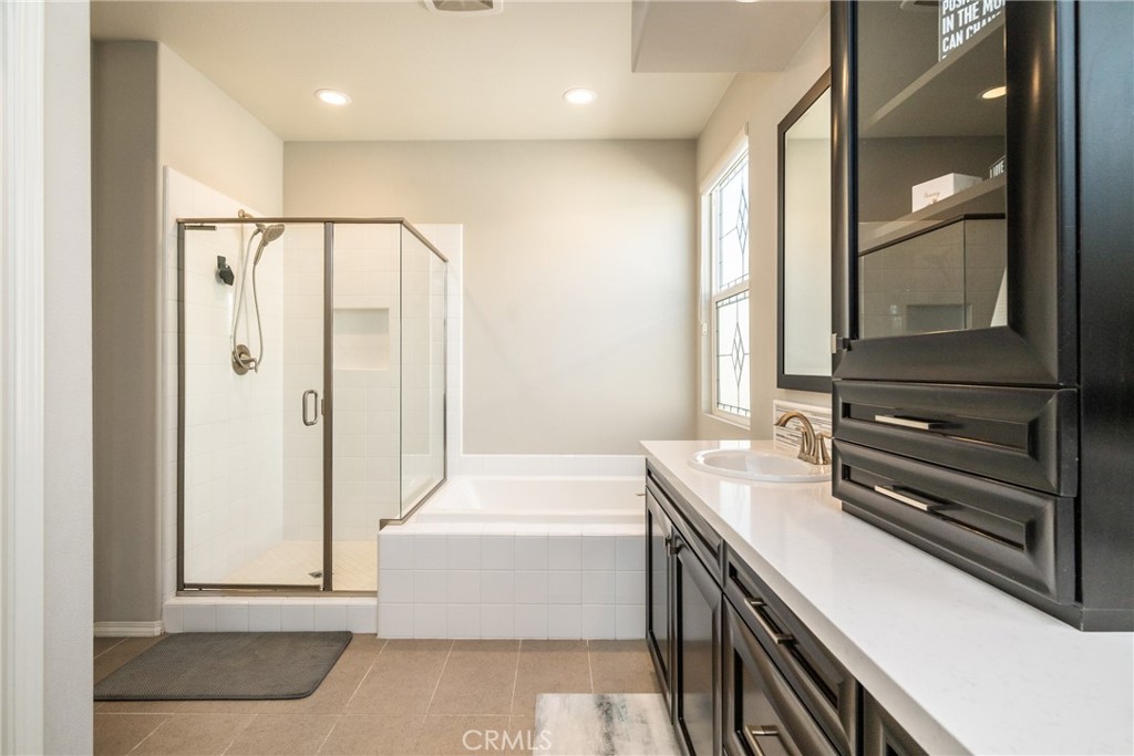 32390 Magee Lane Temecula, CA 92592 - Photo 40 of 75 a bathroom with a tub a sink and a large mirror