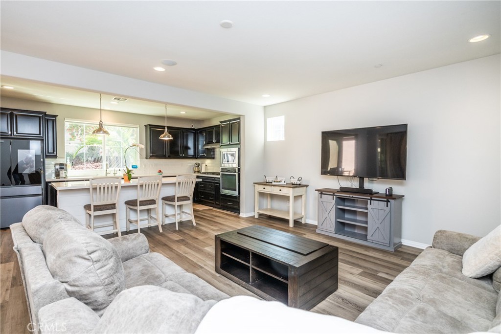 32390 Magee Lane Temecula, CA 92592 - Photo 6 of 75 a living room with furniture a flat screen tv and kitchen view