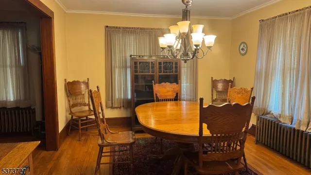 a dining room with furniture a chandelier and wooden floor