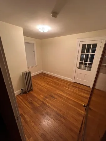 a view of empty room with wooden floor and windows