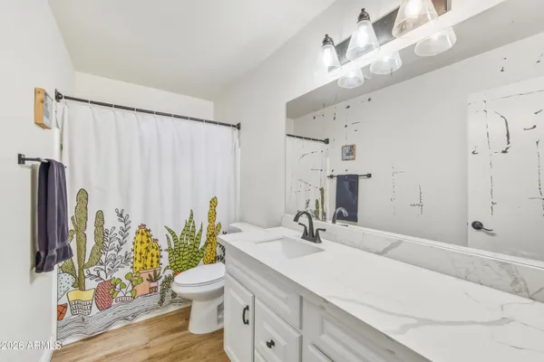 a kitchen with stainless steel appliances granite countertop a refrigerator a stove top oven a sink dishwasher and white cabinets with wooden floor