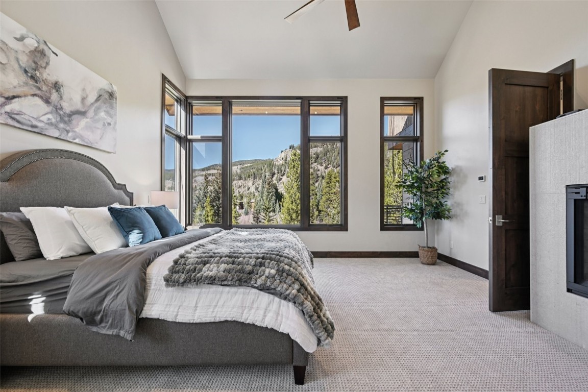 27 West Independence Road Keystone, CO 80435 - Photo 19 of 48 Carpeted bedroom featuring vaulted ceiling, a ceiling fan, and a glass covered fireplace