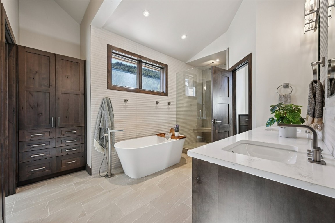 27 West Independence Road Keystone, CO 80435 - Photo 20 of 48 Bathroom with vaulted ceiling, a stall shower, double vanity, a soaking tub, and recessed lighting