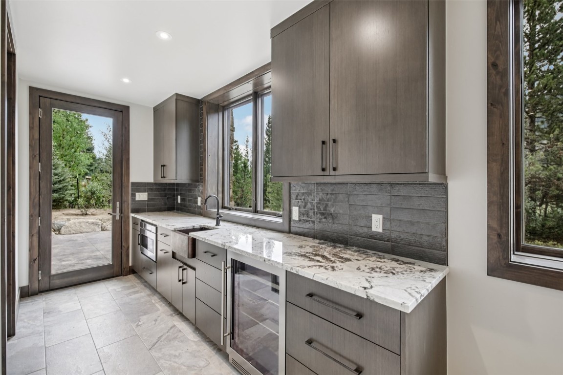 27 West Independence Road Keystone, CO 80435 - Photo 29 of 48 Kitchen with backsplash, beverage cooler, light stone counters, modern cabinets, and recessed lighting