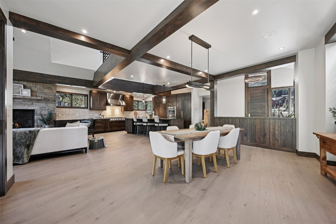 27 West Independence Road Keystone, CO 80435 - Photo 4 of 48 Dining area with beamed ceiling, light wood-style floors, a stone fireplace, and recessed lighting
