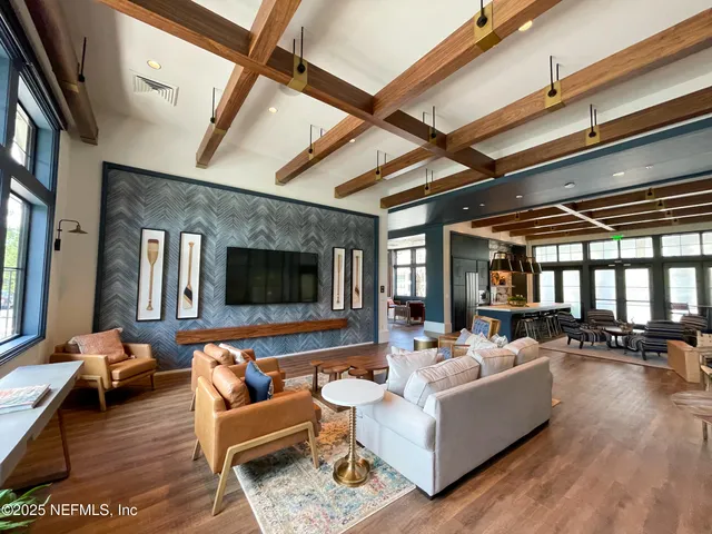a living room with furniture and floor to ceiling windows