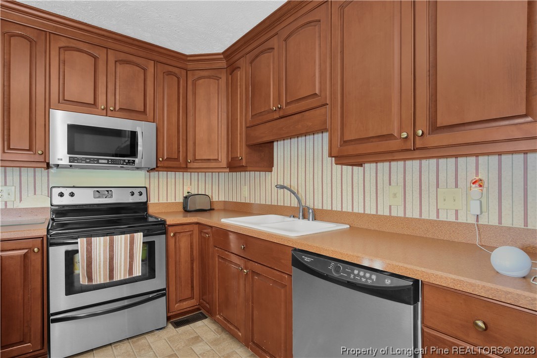 6015 Goldsboro Road Wade, NC 28395 - Photo 24 of 50 a kitchen with stainless steel appliances granite countertop a sink stove and microwave