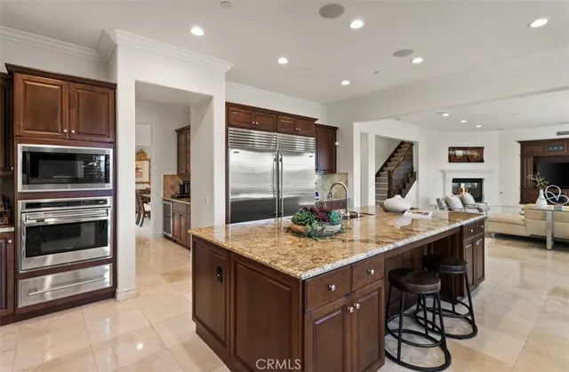 a kitchen with kitchen island granite countertop wooden cabinets and stainless steel appliances