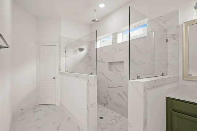 a bathroom with a shower and a glass door