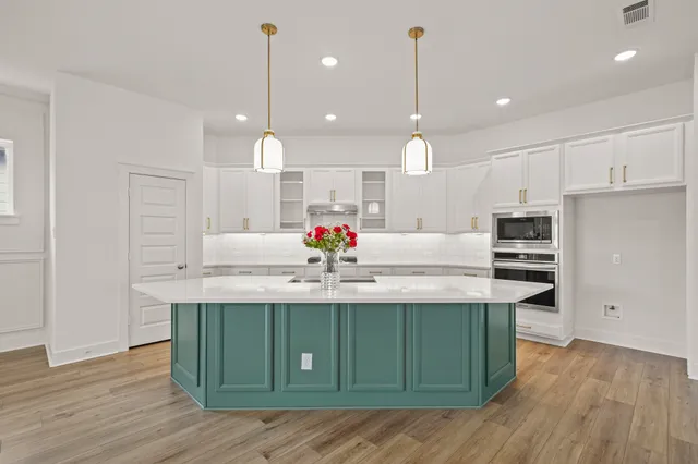 a kitchen with kitchen island a sink stainless steel appliances and cabinets
