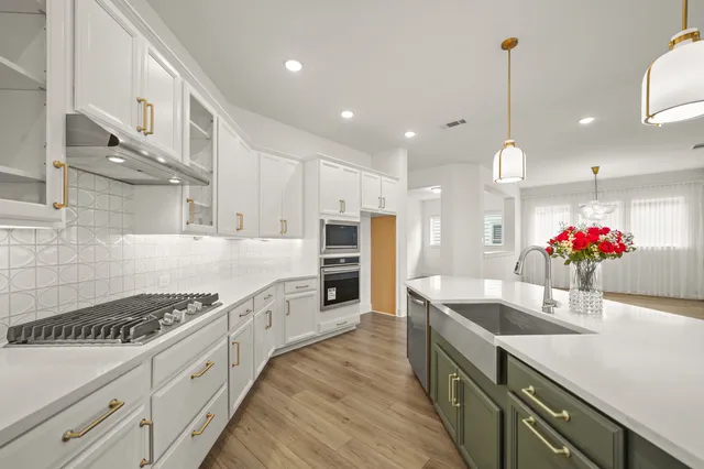 a kitchen with granite countertop a sink stove and cabinets