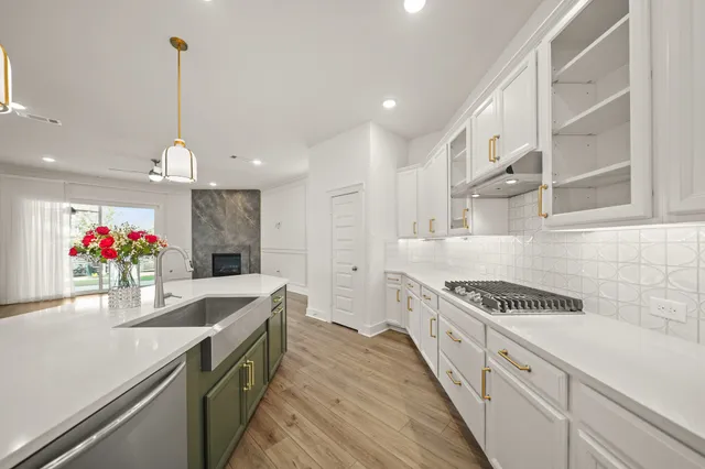 a kitchen with granite countertop a white stove top oven sink and cabinets