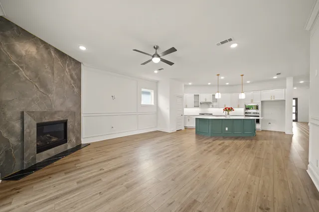 a view of kitchen with kitchen island wooden floor center island and stainless steel appliances