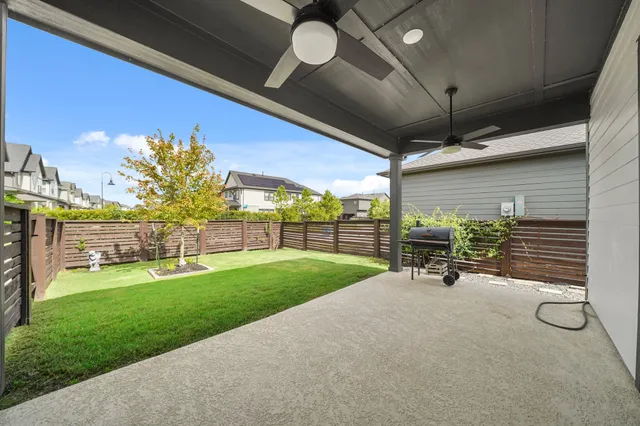 a view of a backyard with table and chairs under an umbrella