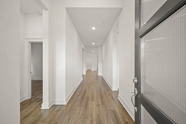 a view of a hallway with wooden floor and staircase