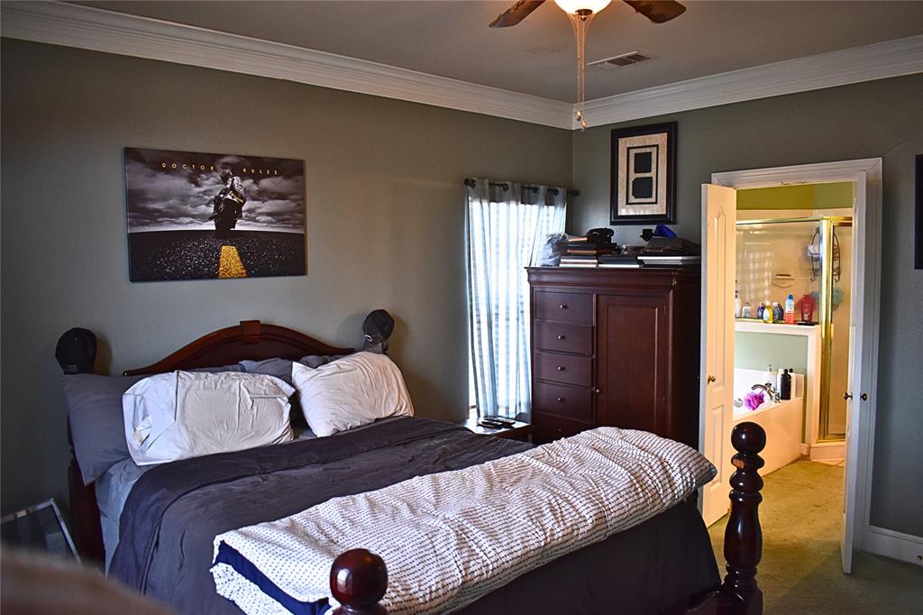 311 Ridge Hollow Trail Venus, TX 76084 - Photo 12 of 38 a bedroom with a bed and a chandelier