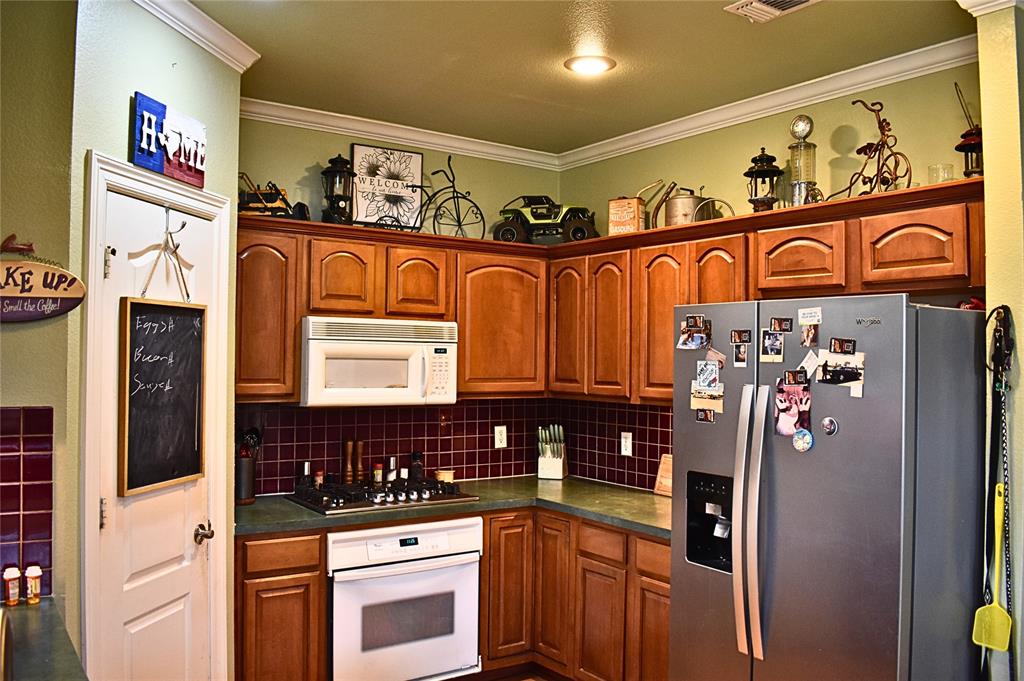 311 Ridge Hollow Trail Venus, TX 76084 - Photo 28 of 38 a kitchen with stainless steel appliances granite countertop a refrigerator and a stove top oven