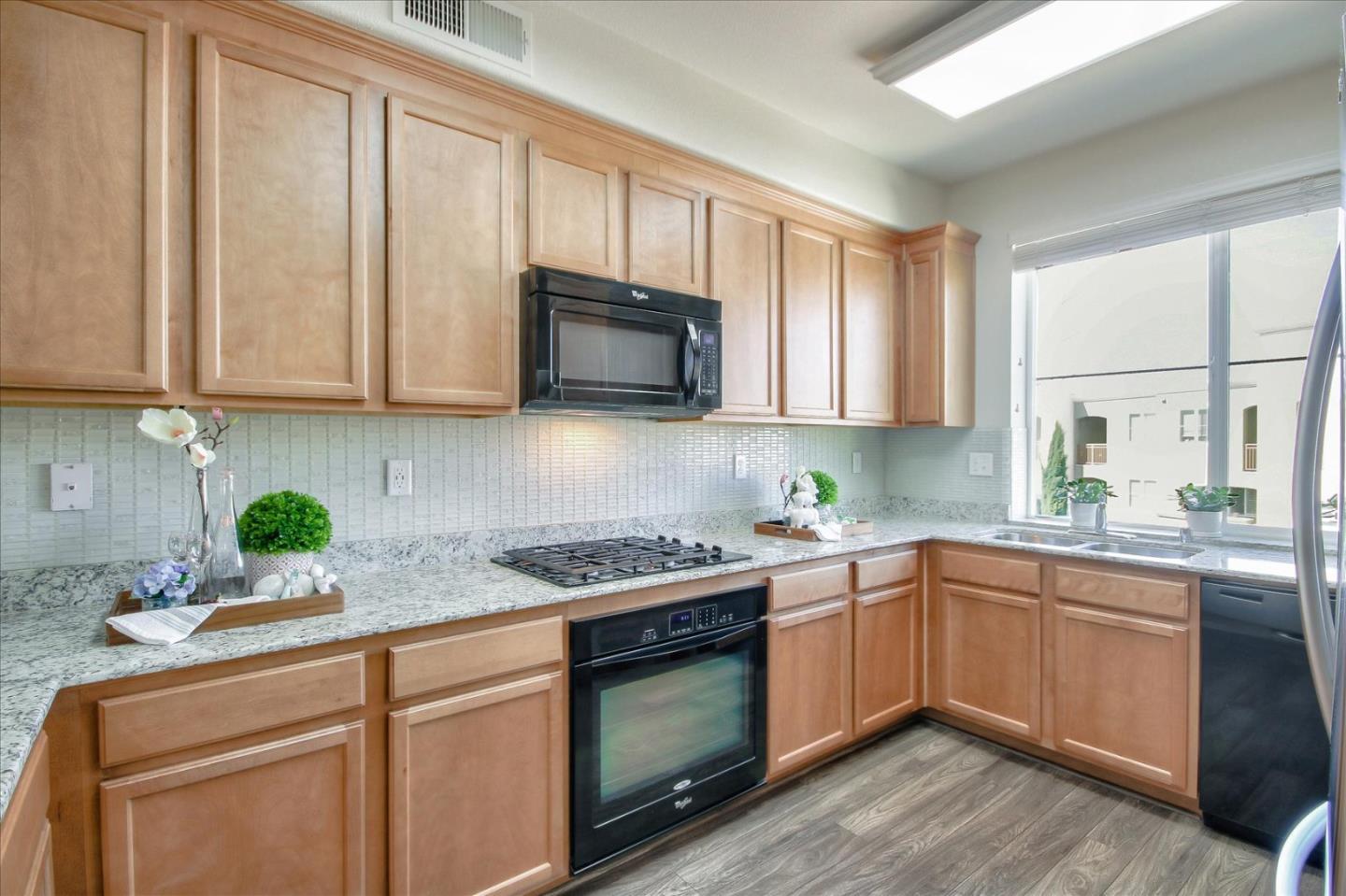 4712 Norris Canyon Road, Unit 202 San Ramon, CA 94583 - Photo 7 of 30 a kitchen with granite countertop cabinets stainless steel appliances a sink and window
